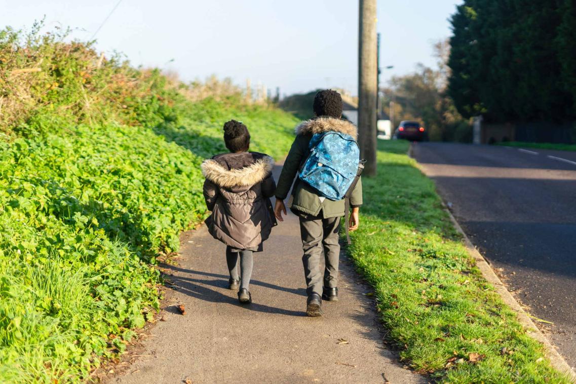 A photo of two children walking to school