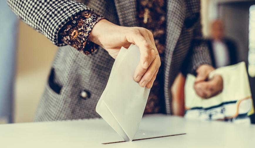 Man putting vote into ballot box