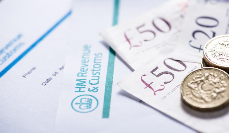 Image of an HMRC form with £50 notes and £1 coins on top