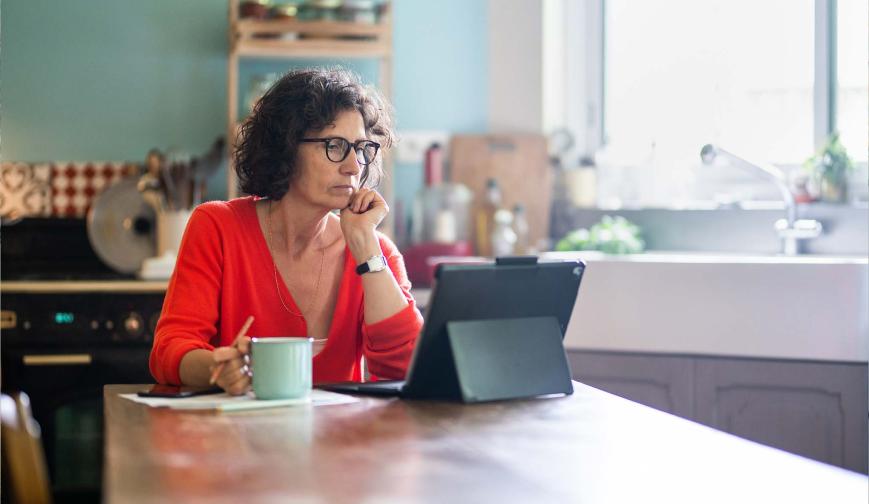 Woman sitting in a kitchen at a laptop