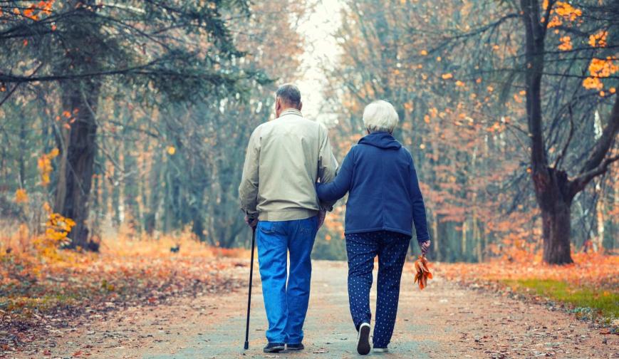 retired couple walking in park