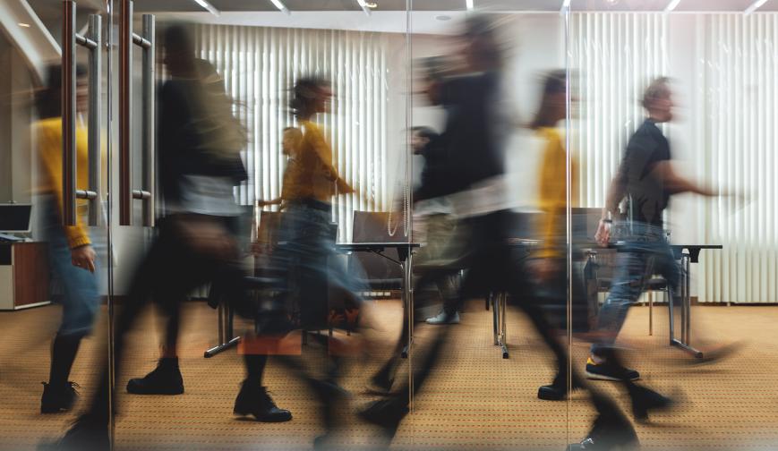 People walking in opposite directions through an office space