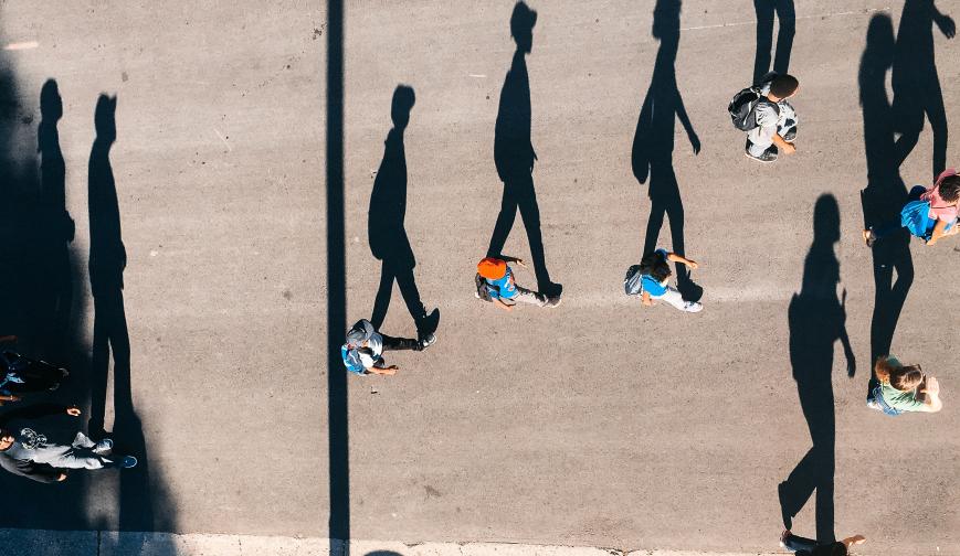 Image of people walking alongside their shadow
