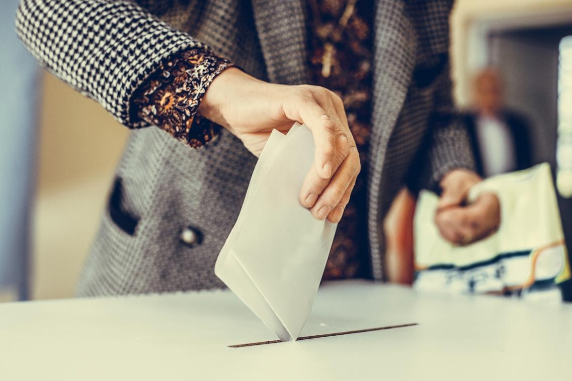 Man putting vote into ballot box