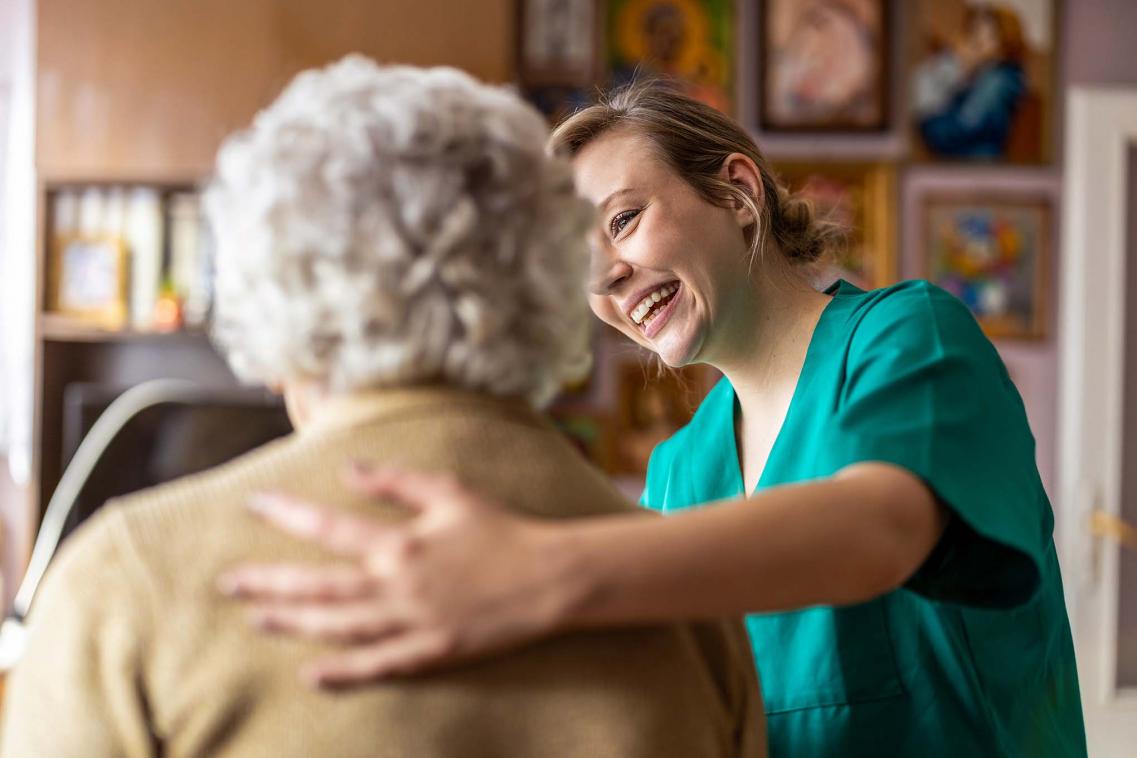 Elderly woman supported by a nurse