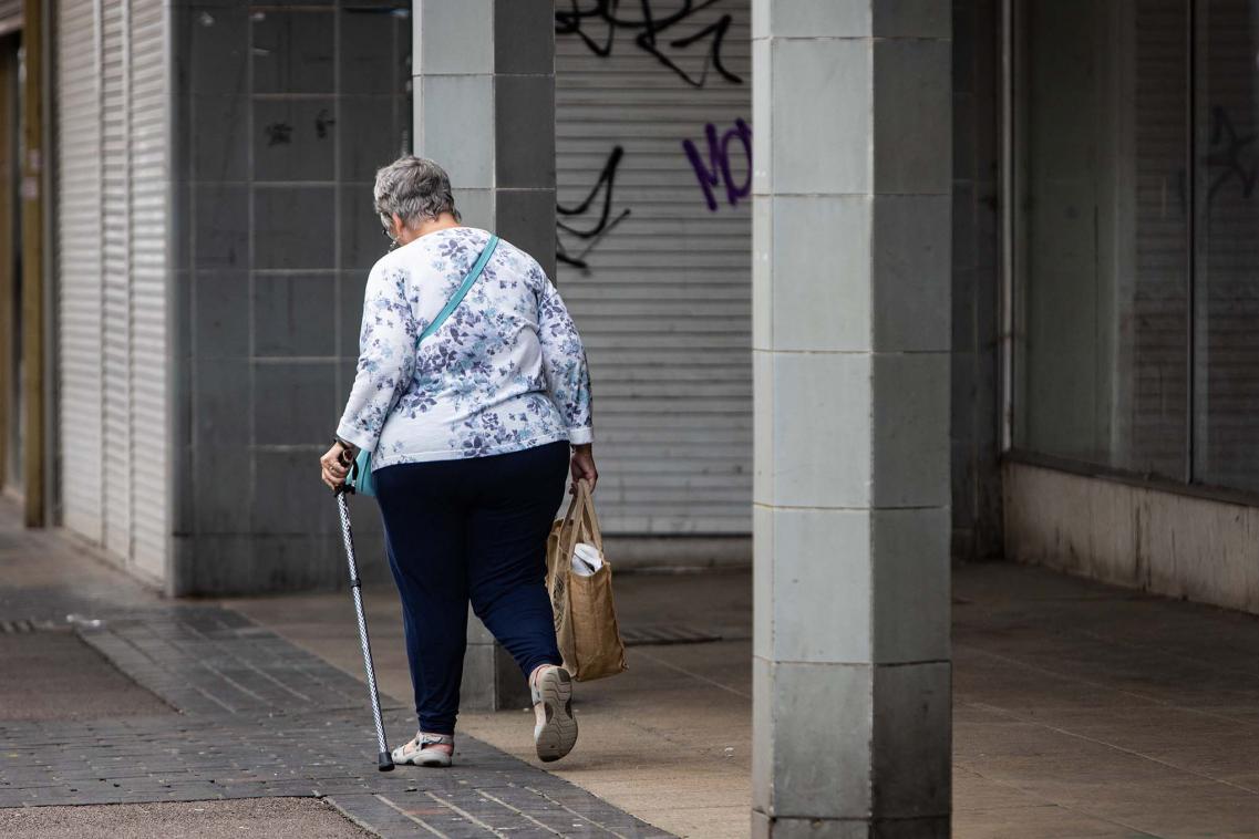 Older woman walking down high street