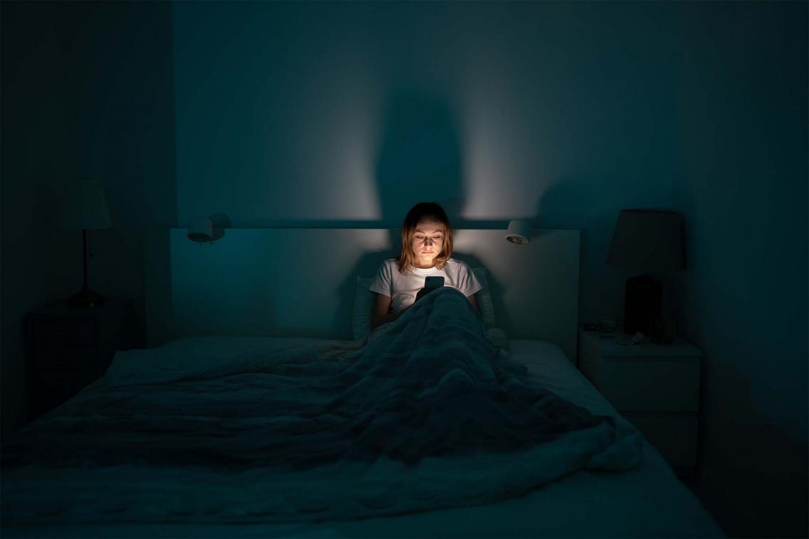 Woman on phone in bed