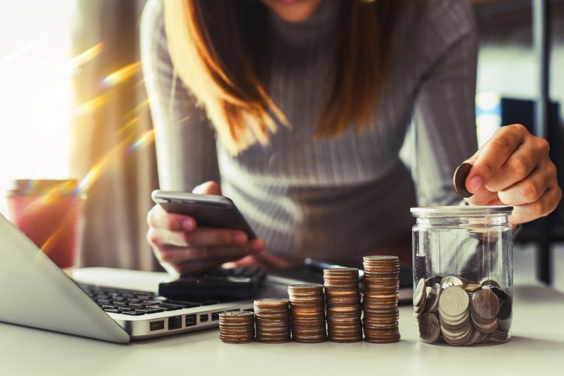 A photo of a woman saving money into a jar