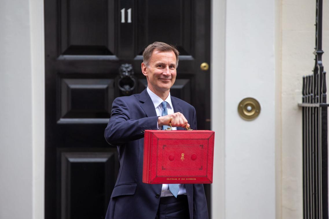 A photo of Jeremy Hunt holding the budget box