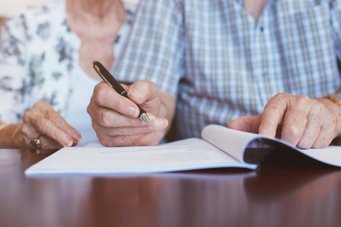 Older couple signing document