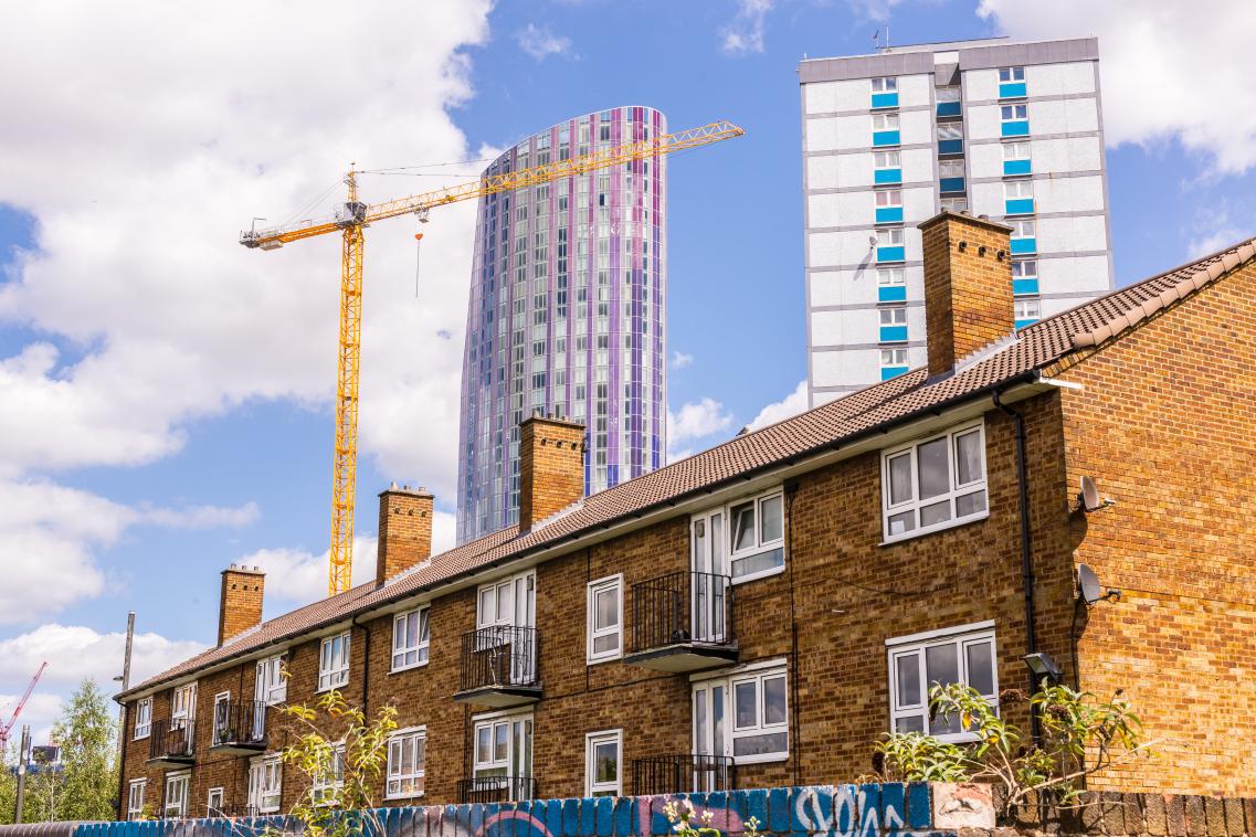 Small block of flats with council house and modern skyscraper