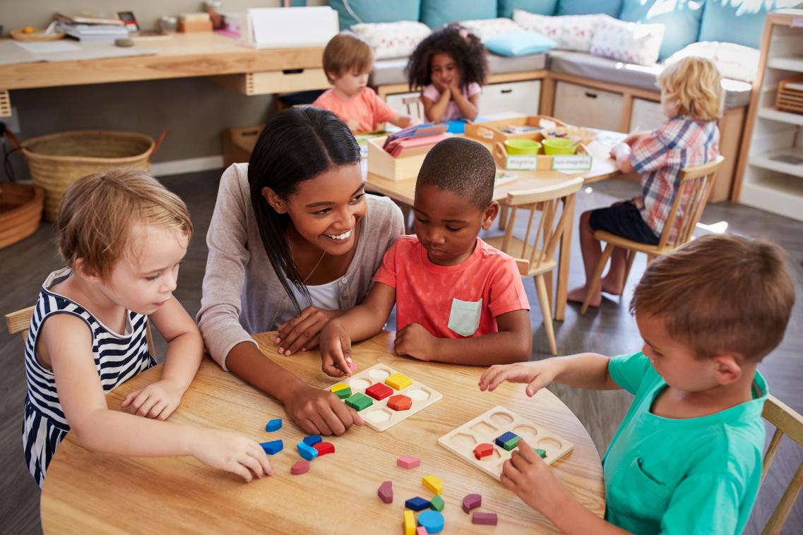 Image of children sorting shapes with teacher