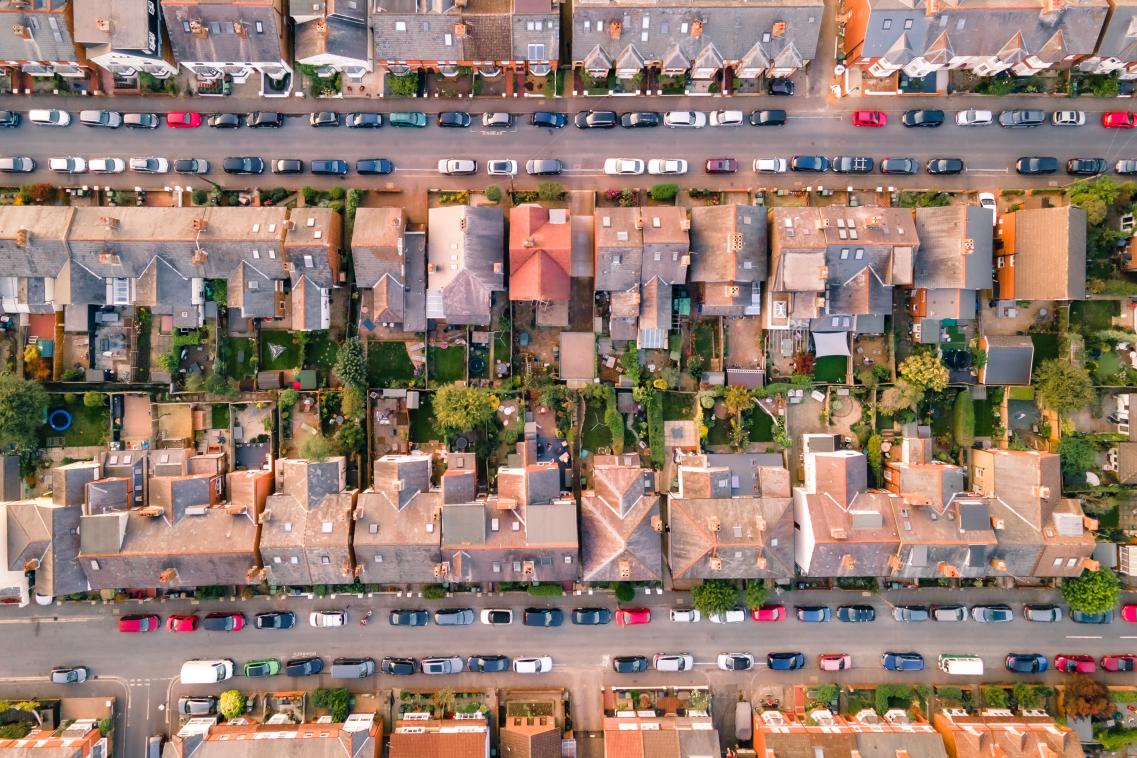 Aerial view of houses and parked cars