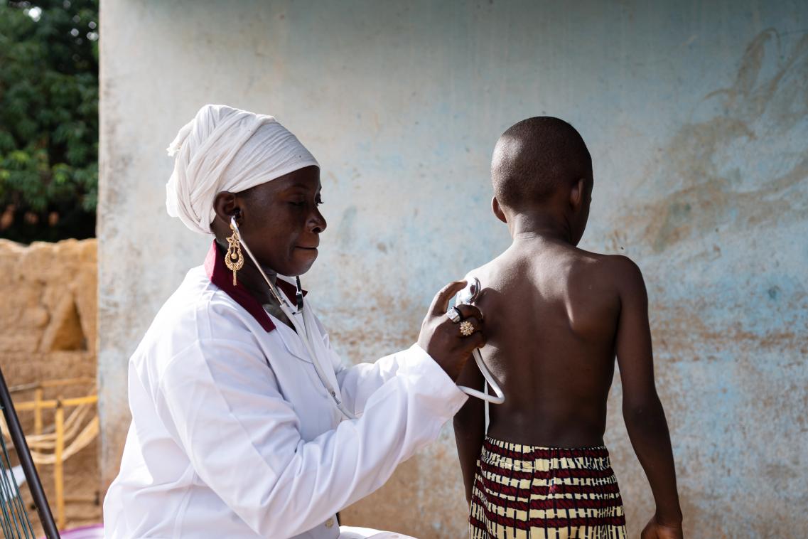 Doctor with stethoscope listening to a young child's respiratory sounds