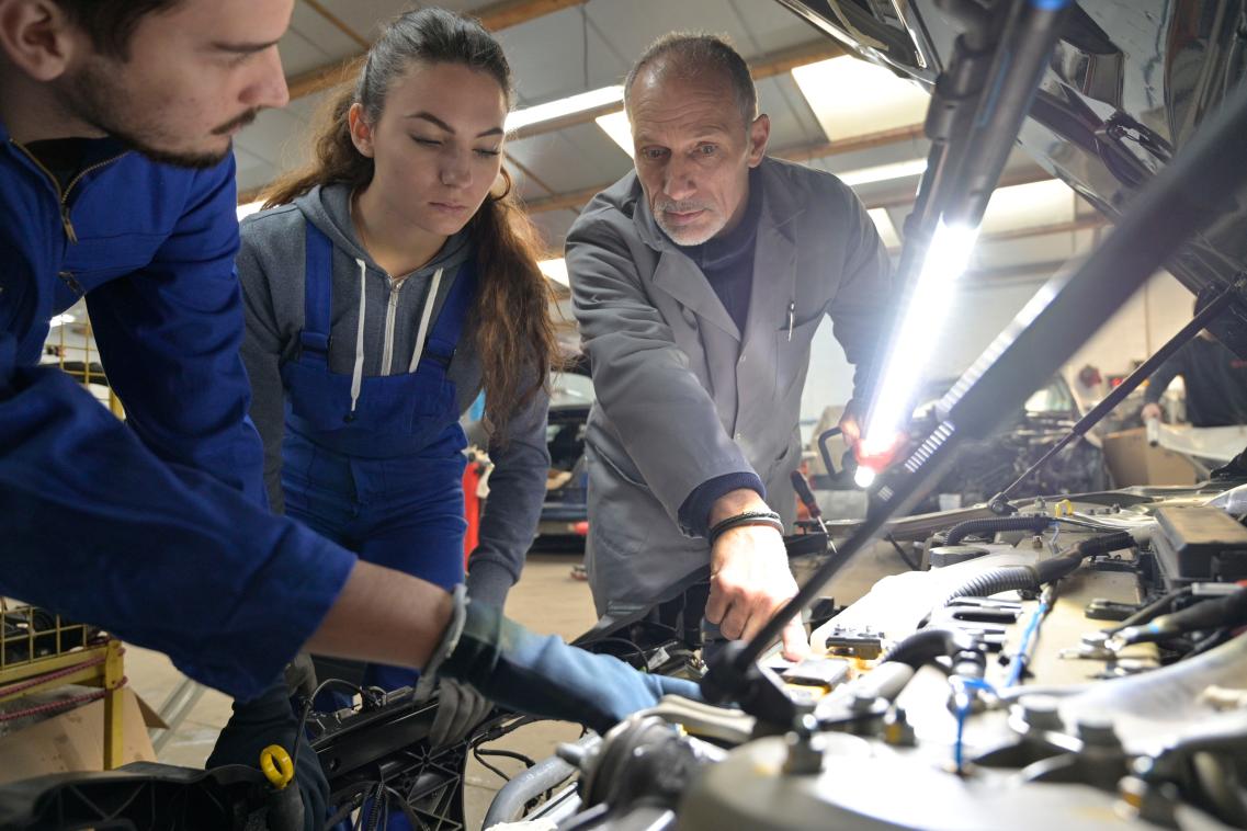 Instructor with students working on engine