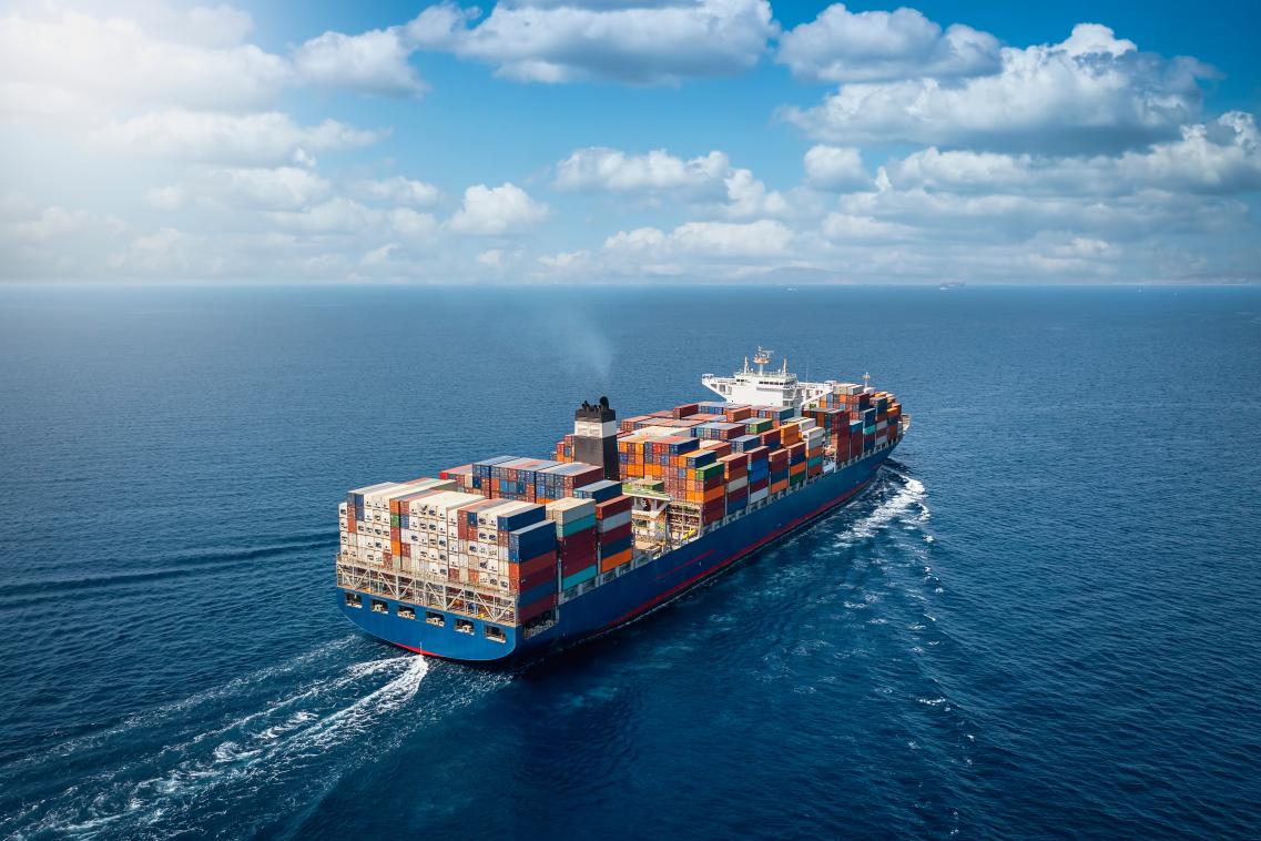 Image of a large container cargo ship sailing across the ocean