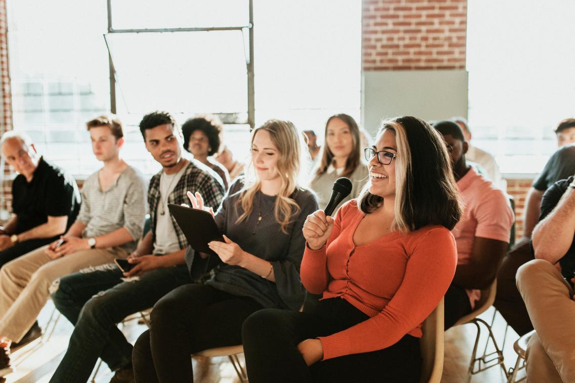 Image of a woman asking a question in a conference