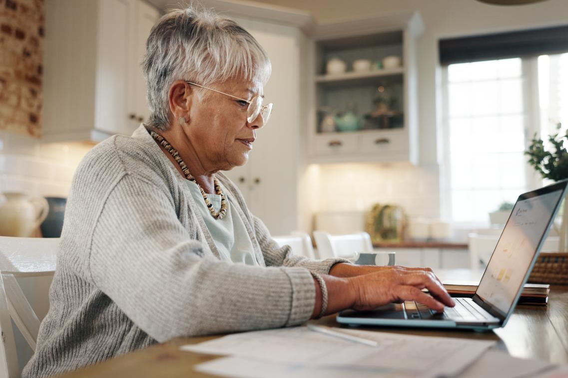 Elderly woman working on laptop for financial planning