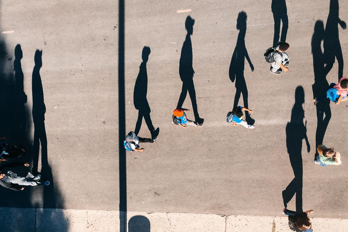 Image of people walking alongside their shadow
