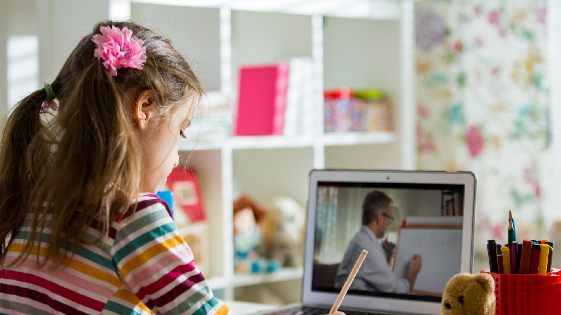 An image of a child using a laptop to learn from home