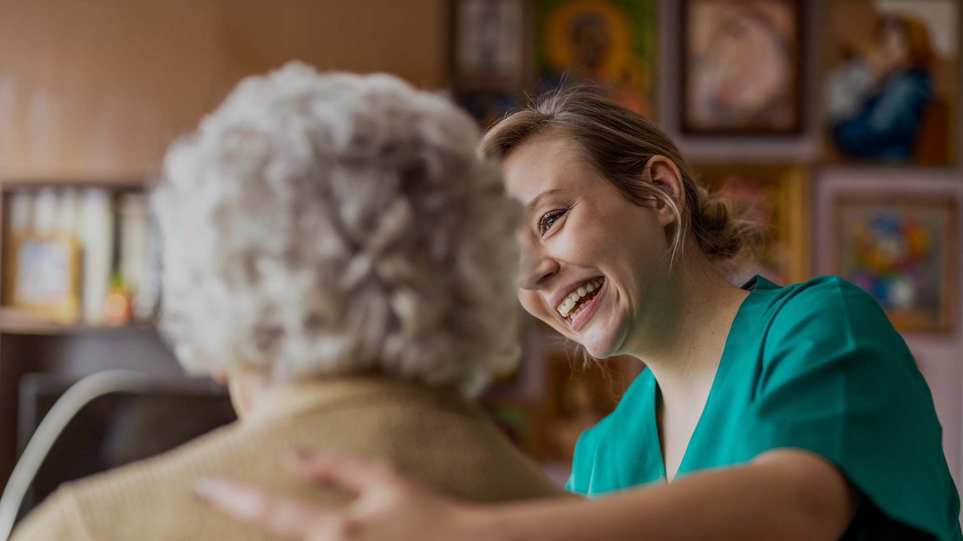 Elderly woman supported by a nurse