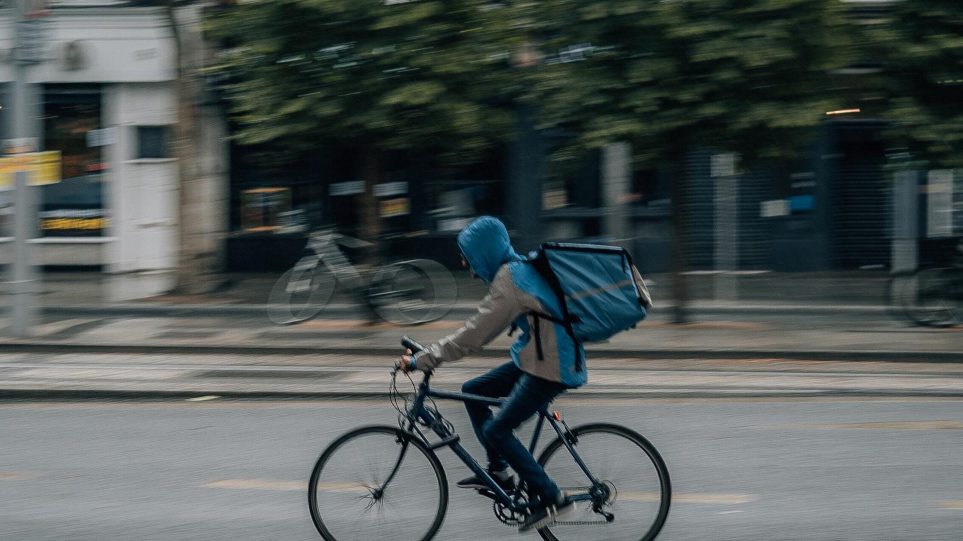 An image of a food delivery driver on a bicycle