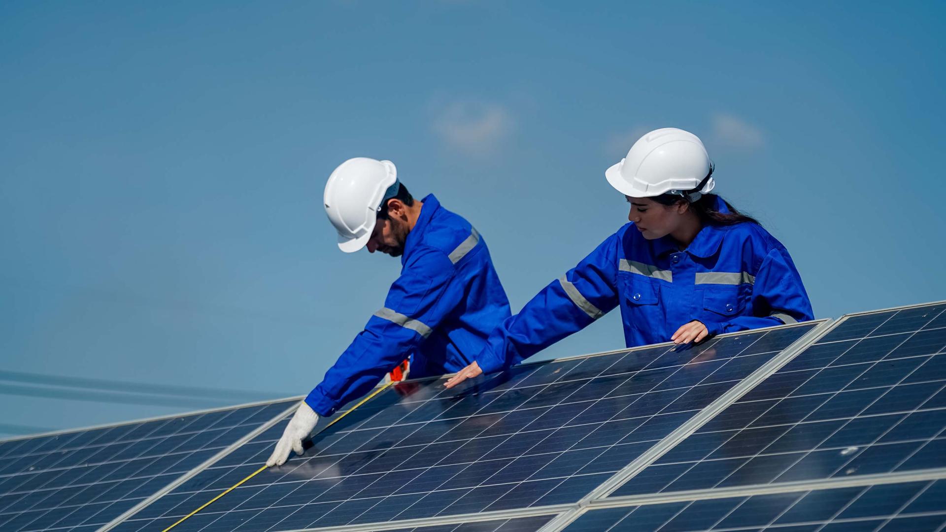 Apprentice and worker on solar panel