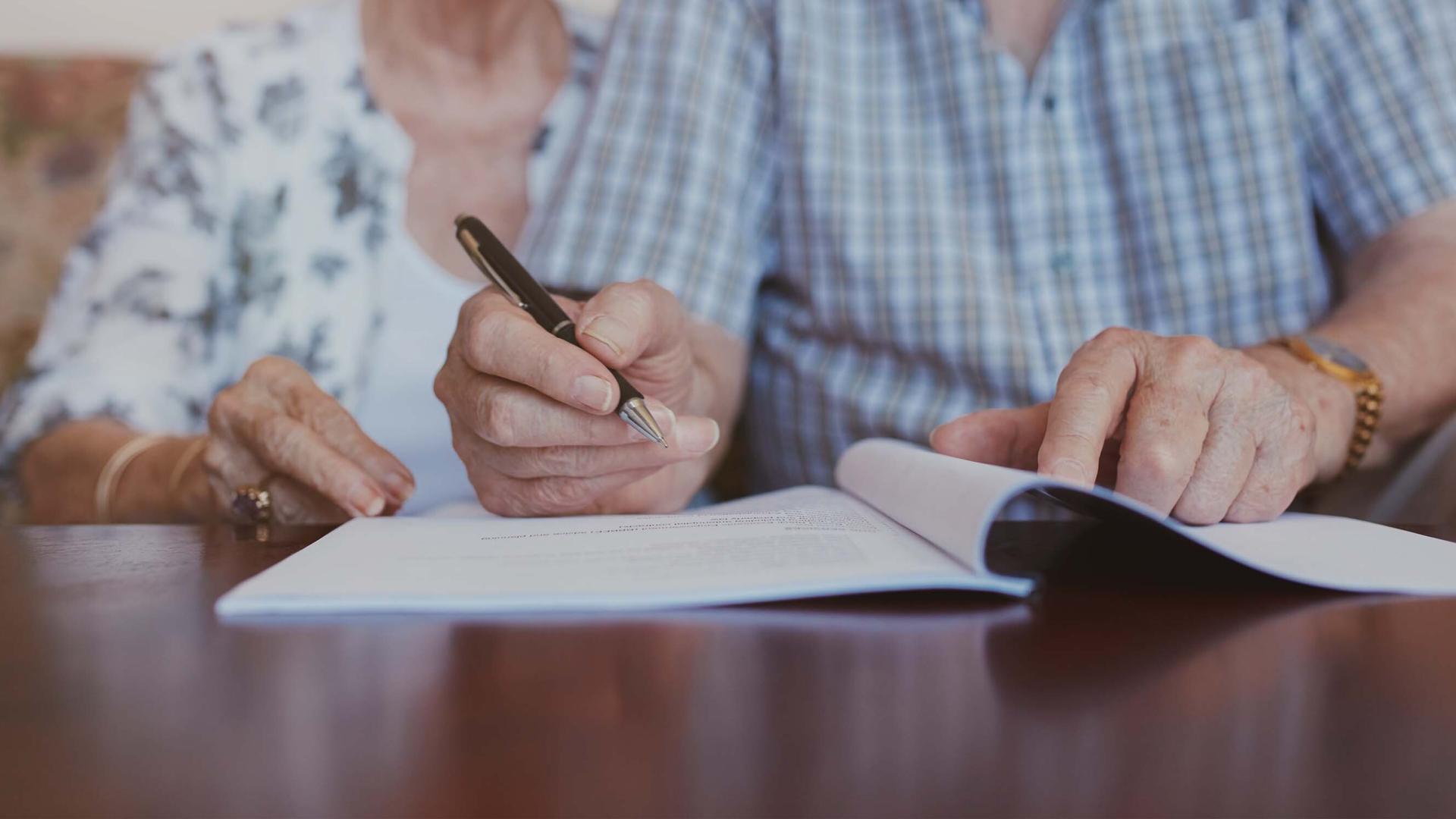 Older couple signing document