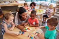Image of children sorting shapes with teacher