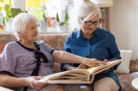 Image of elderly mother and daughter looking through a picture album