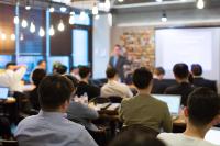 Image from back of the room at a workshop, with speaker presenting to room