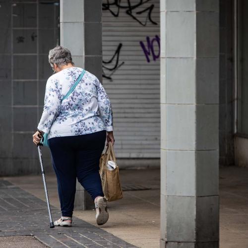 Older woman walking down high street