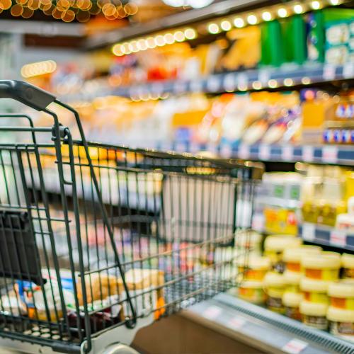 Supermarket trolley next to shelves of butter