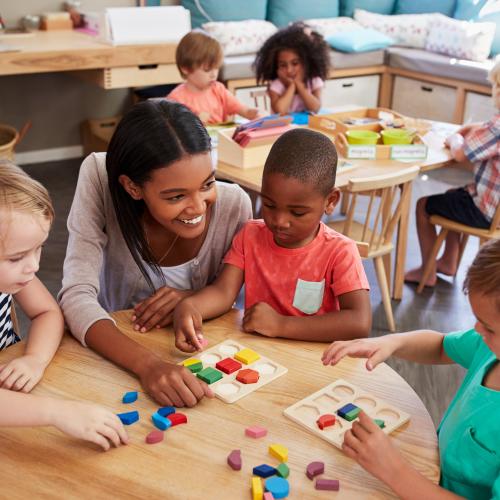 Image of children sorting shapes with teacher