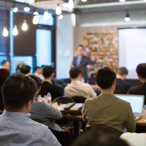 Image from back of the room at a workshop, with speaker presenting to room