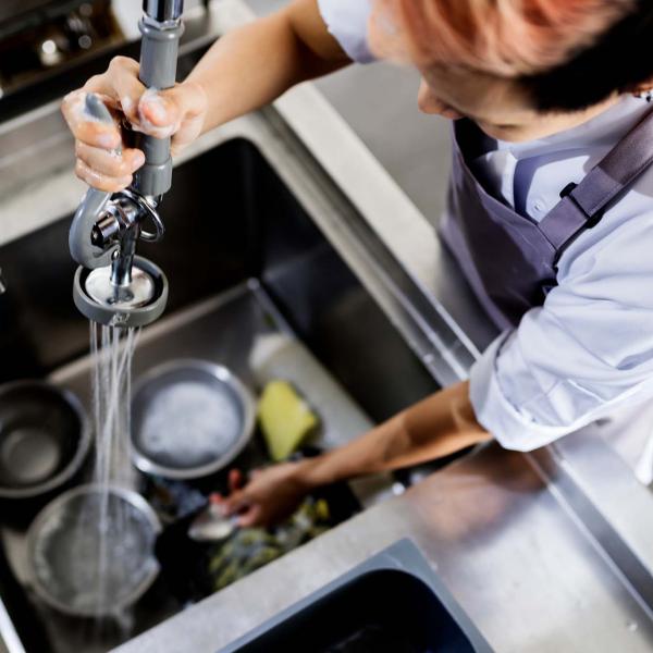 Kitchen porter washing dishes