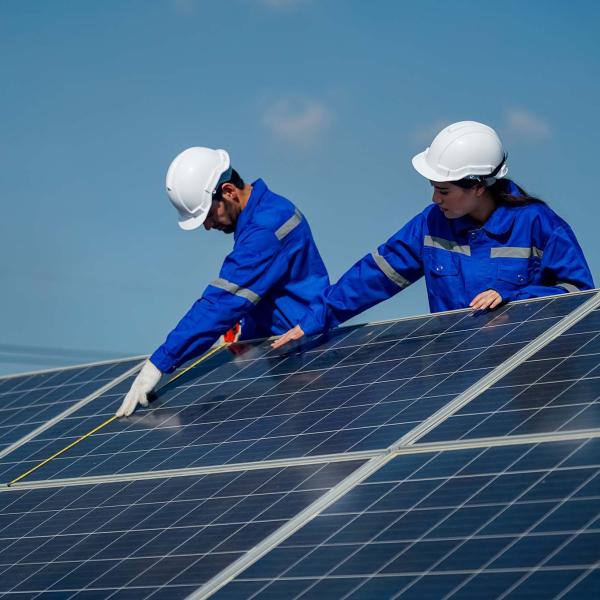 Apprentice and worker on solar panel