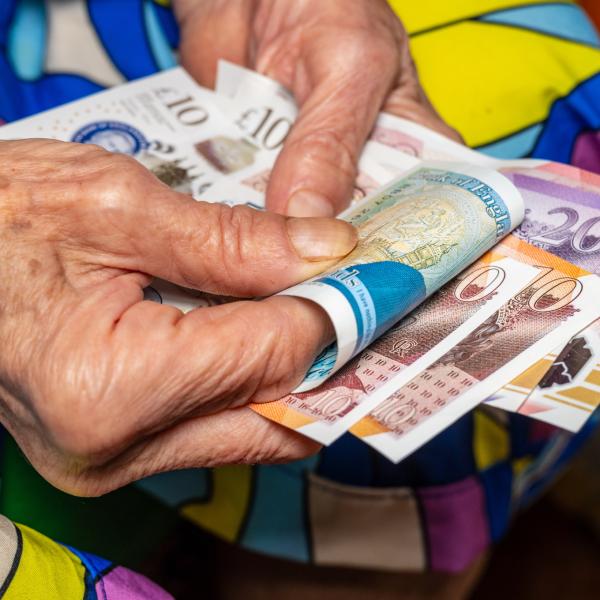 A photo of an older person holding money