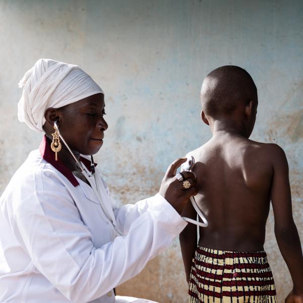 Doctor with stethoscope listening to a young child's respiratory sounds