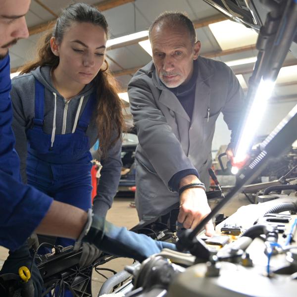 Instructor with students working on engine