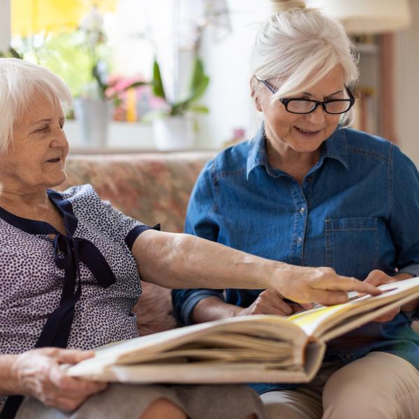 Image of elderly mother and daughter looking through a picture album