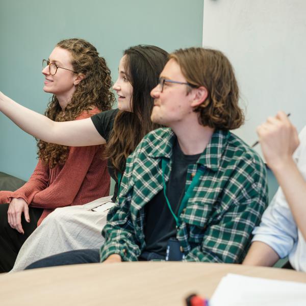 Image of four staff members in a meeting looking at a presentation